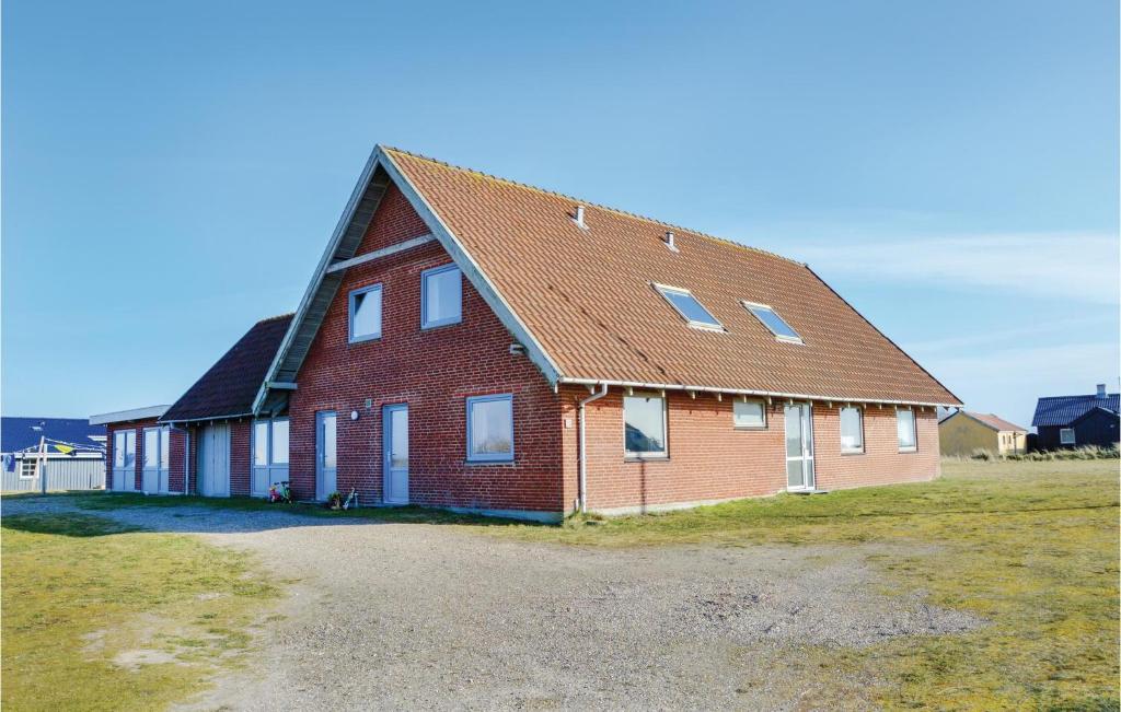 una gran casa de ladrillo rojo con techo de gambrel en Vejlgrd, en Nørre Lyngvig