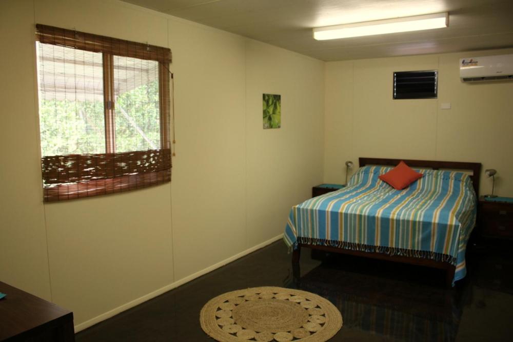 Habitación pequeña con cama y ventana en Spring Homestead en Howard Springs