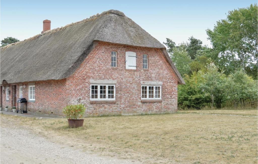 a red brick house with a thatched roof at Two-Bedroom Apartment In Romo in Rømø Kirkeby