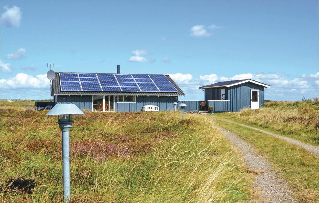 een huis met zonnepanelen aan de kant van een weg bij Stunning Home In Fan With Sauna in Sønderho