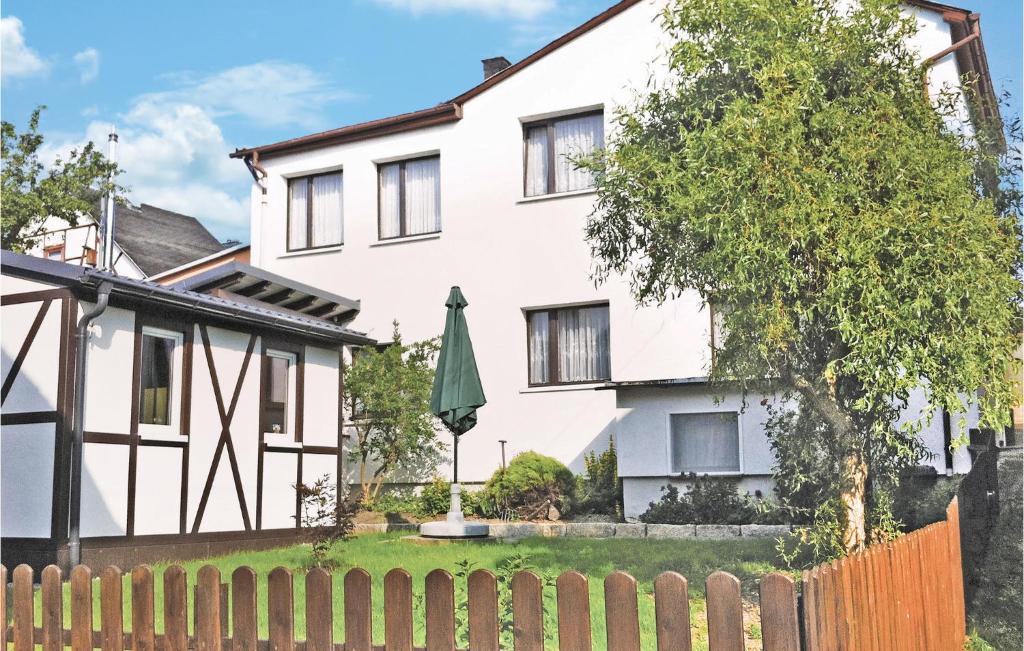 a white house with a fence and an umbrella at Gorgeous Home In Grobreitenbach Ot With Kitchen in Herschdorf