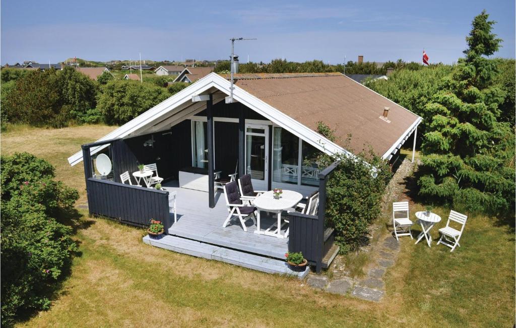 una vista aérea de una casa pequeña con mesa y sillas en Beautiful Home In Ringkbing With Kitchen, en Søndervig