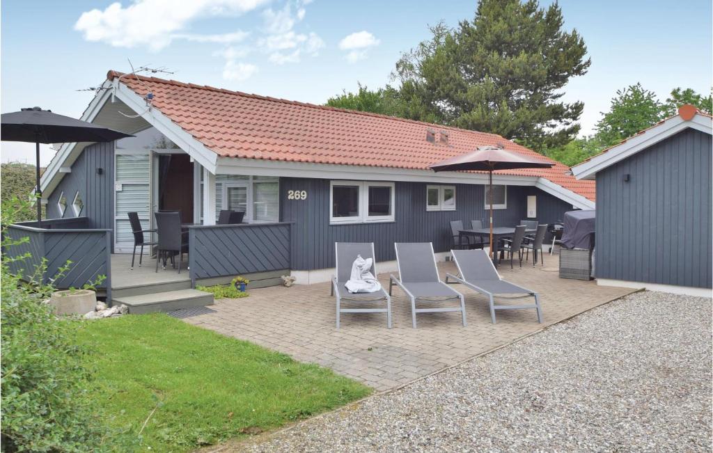 Casa con patio con sillas y sombrillas en Stunning Home In Juelsminde With Sauna en Sønderby
