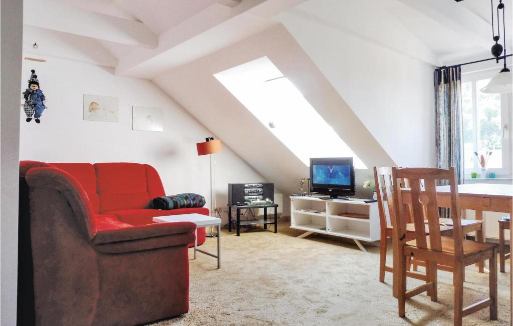 ザンクト・アンドレーアスベルクにあるBeautiful Apartment In Sankt Andreasberg With 2 Bedrooms And Wifiのリビングルーム(赤いソファ、テレビ付)