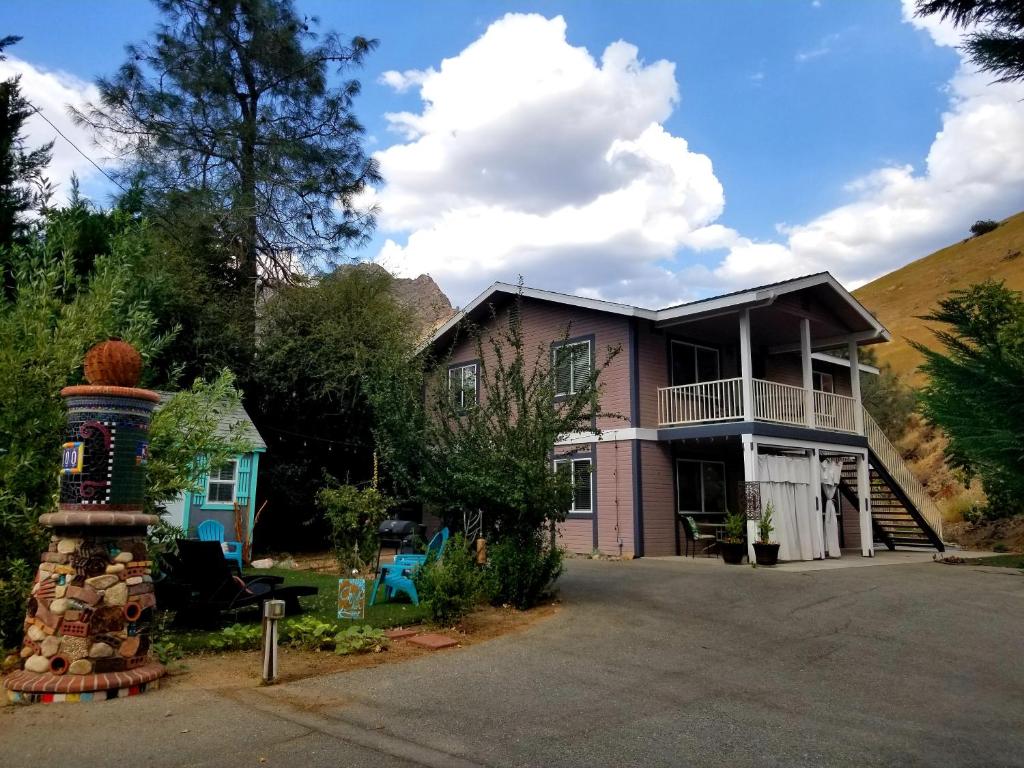 a house with a hill in the background at Sacred Mtn River Suites in Kernville