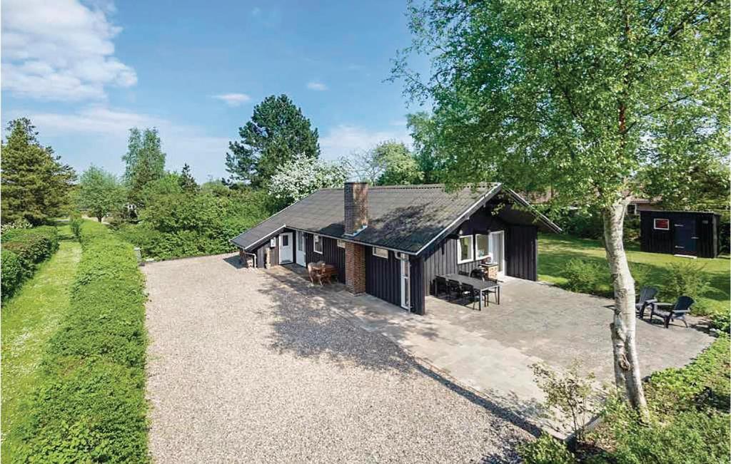 a house with a gravel driveway in front of it at Three-Bedroom Holiday Home In Sydals in Skovbyballe