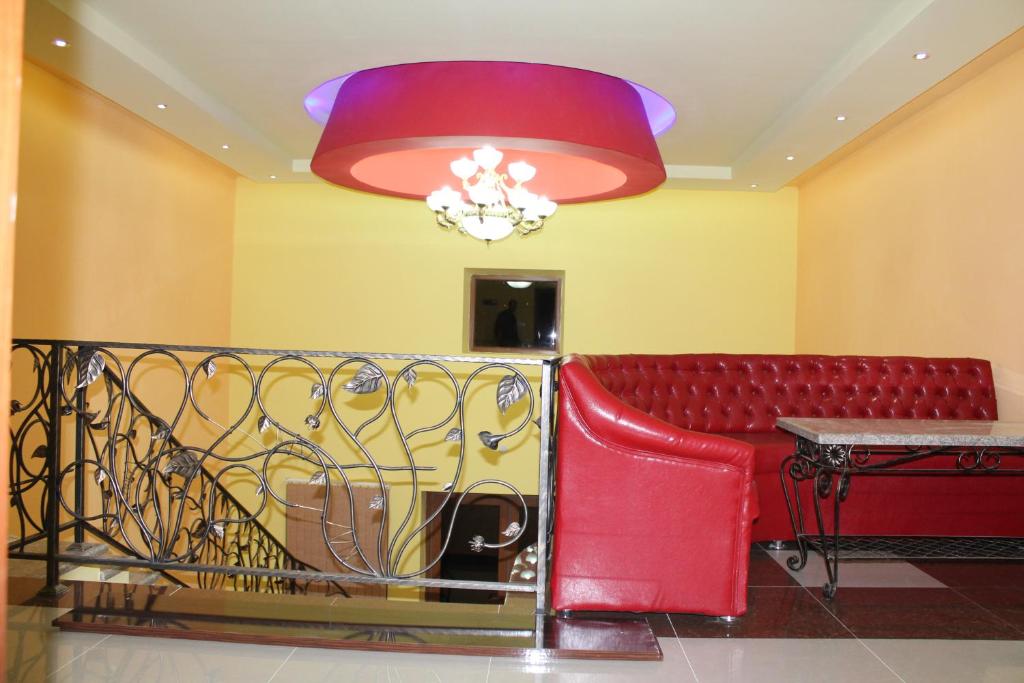 een rode bank in een kamer met een kroonluchter bij Princ Plaza Hotel in Jerevan