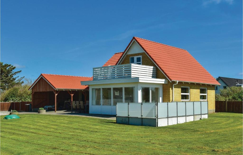 una casa con techo naranja en un patio en 4 Bedroom Awesome Home In Ringkbing, en Søndervig