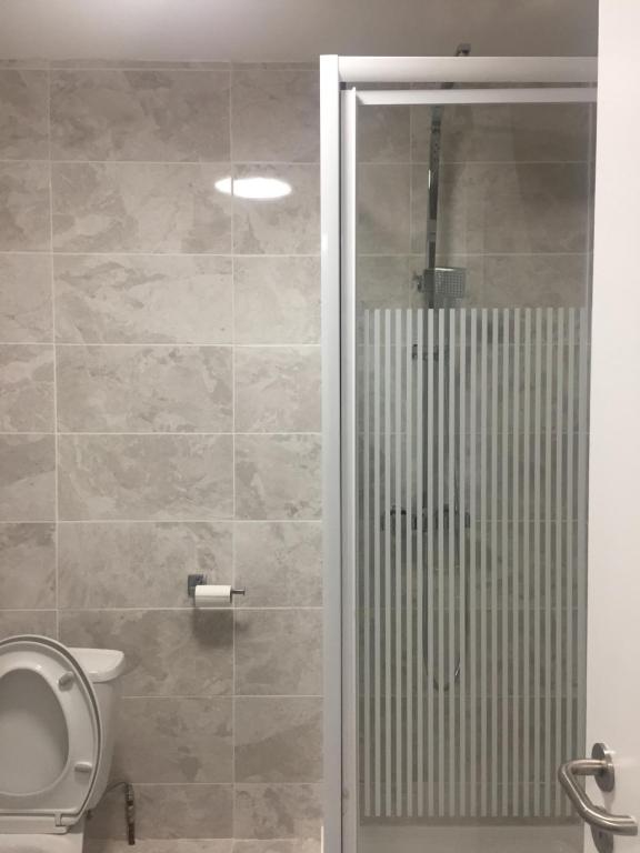 a bathroom with a shower, toilet, and sink at Rahman Piccadilly Hostel in Manchester