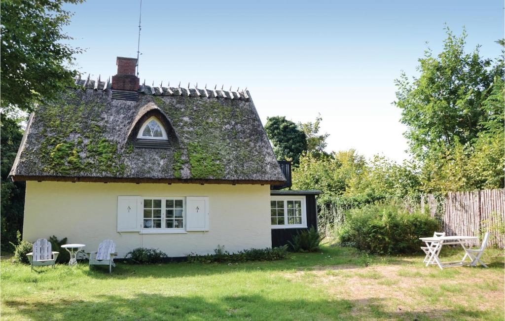a small white house with a roof at Two-Bedroom Holiday Home In Hornbak in Hornbæk