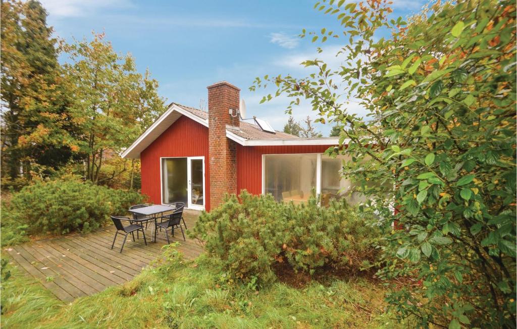 a red house with a picnic table on a deck at Gorgeous Home In Spttrup With Kitchen in Spottrup