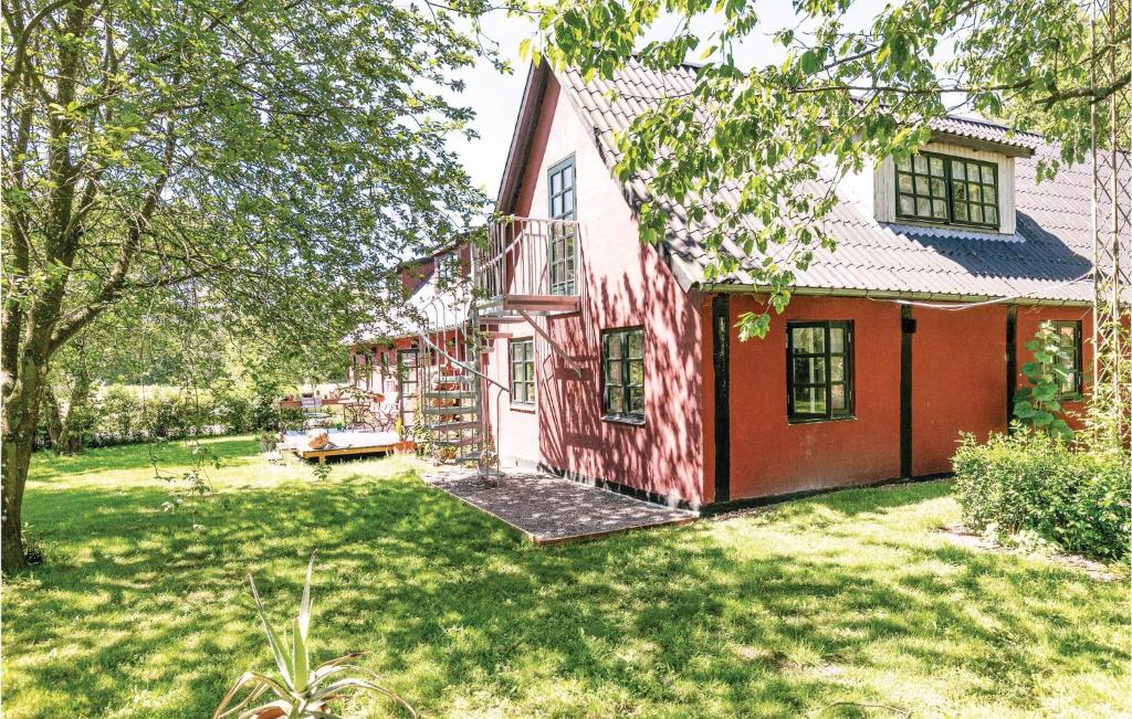 an exterior view of a red house with a yard at 0-Bedroom Apartment In Nexo in Neksø