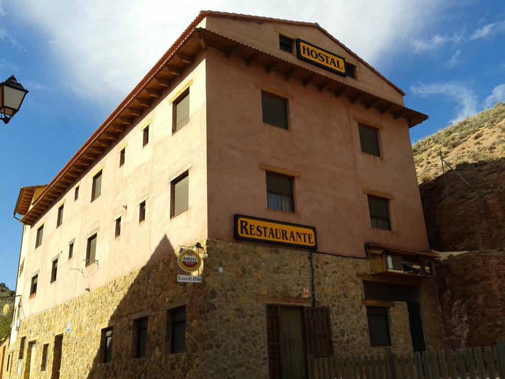 un edificio con un cartel en el costado en Hostal El Olmo en Camarena de la Sierra