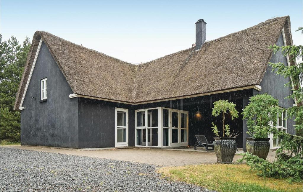 una casa negra con techo de gambrel en Beautiful Home In Blvand With 5 Bedrooms, Sauna And Wifi en Blåvand