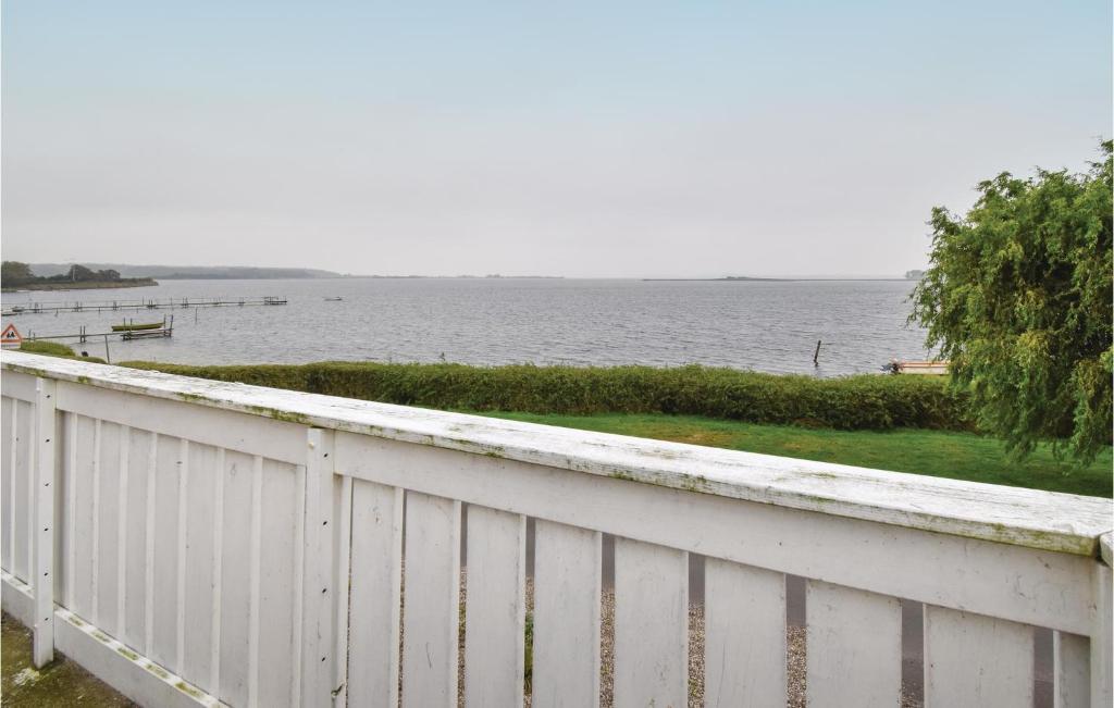 einen weißen Zaun mit Blick auf das Wasser in der Unterkunft Gorgeous Home In Haarby With Kitchen in Hårby