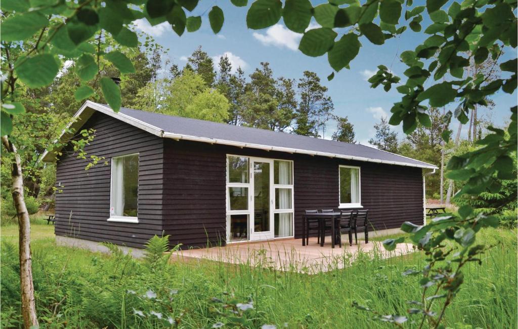 a black house with a picnic table in front of it at Amazing Home In Hirtshals With Wifi in Hirtshals