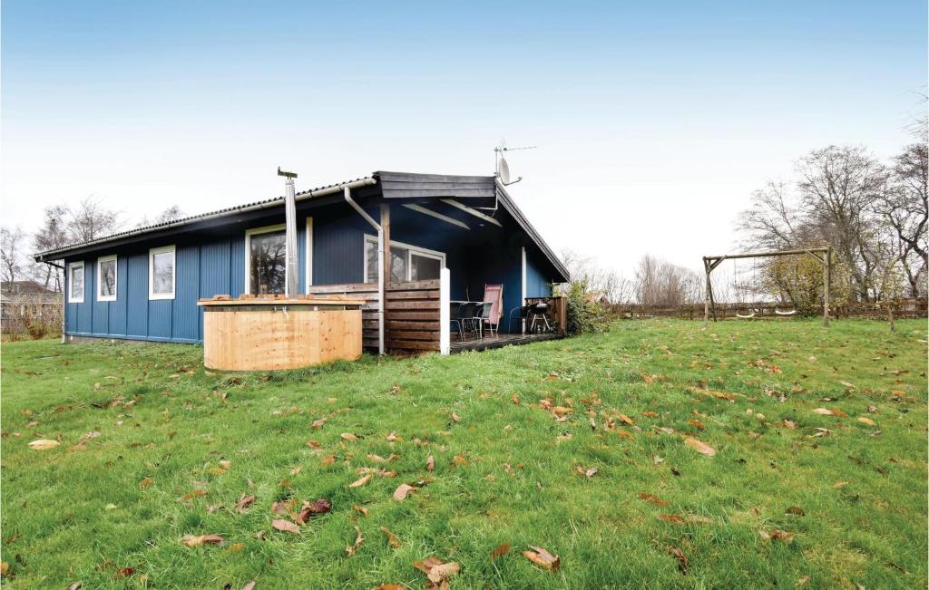 una casa azul en un campo con césped en Stunning Home In Brenderup Fyn With Wifi, en Skovs-Højrup