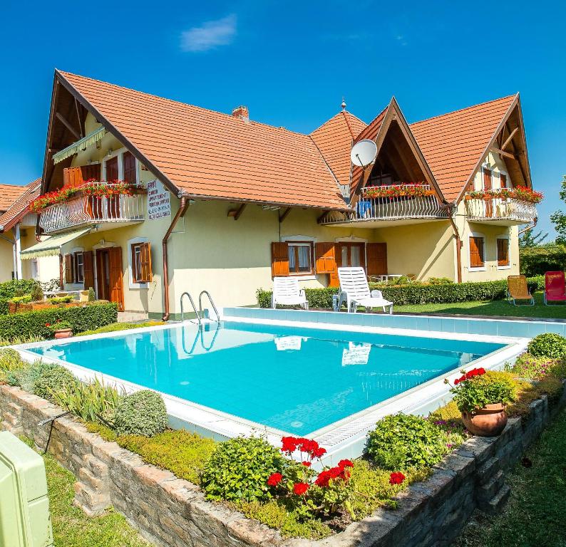 a house with a swimming pool in front of it at Familia Apartment 100/3 in Balatonmáriafürdő