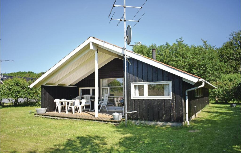 a black shed with a porch and a table and chairs at 4 Bedroom Beautiful Home In Humble in Humble