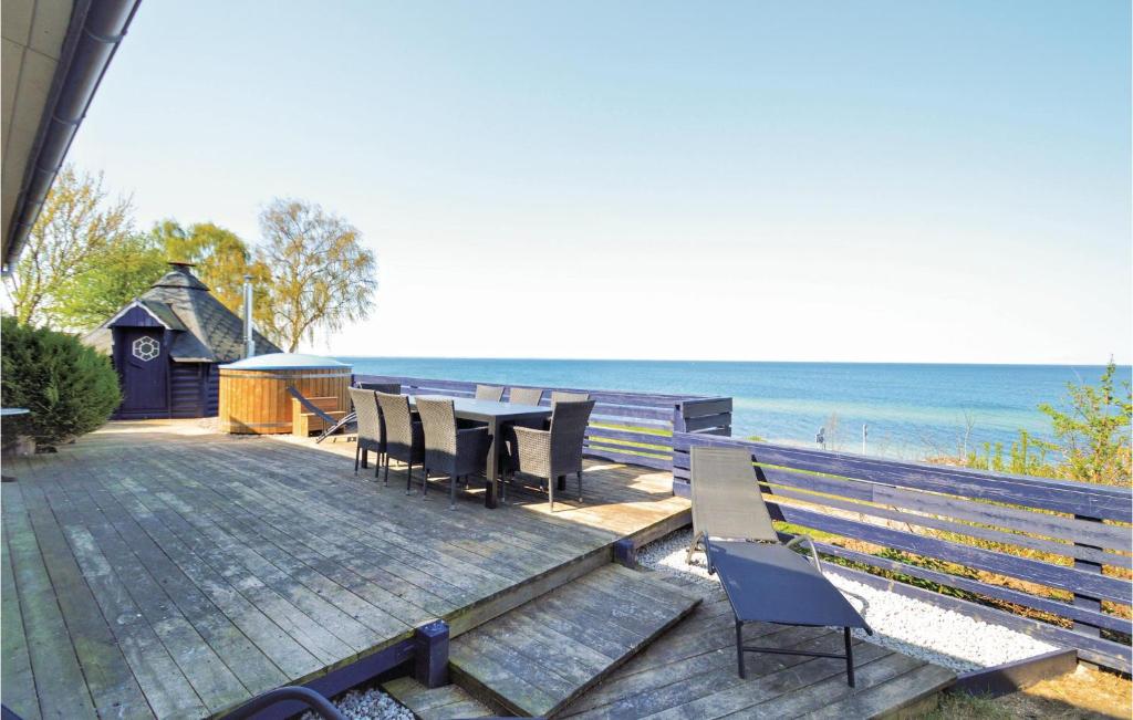 una terraza con sillas, una mesa y el océano en 4 Bedroom Stunning Home In Strby en Strøby