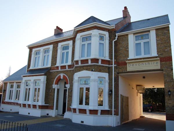 Una gran casa de ladrillo con un cartel. en Devonshire Hotel, en Hornchurch