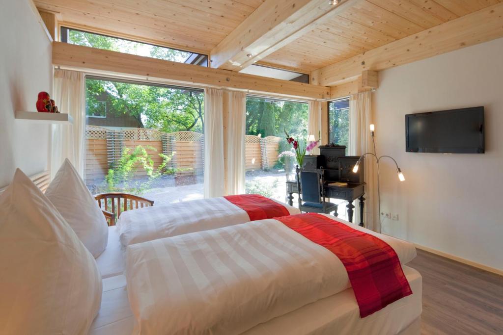 a bedroom with a bed and a large window at Vivere Ad Parcum - Bed And Breakfast in Krefeld