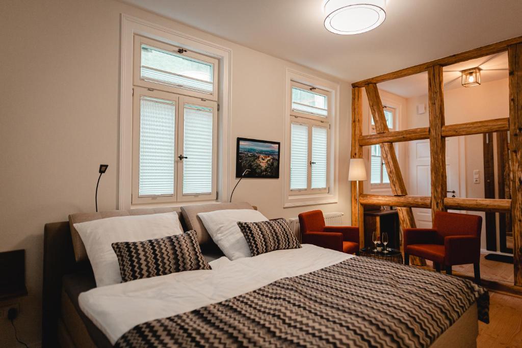 a bedroom with a bed and two windows at Ferienwohnungen an der Salvatorkirche - zentrales Apartmenthaus mit Terrasse in Coburg