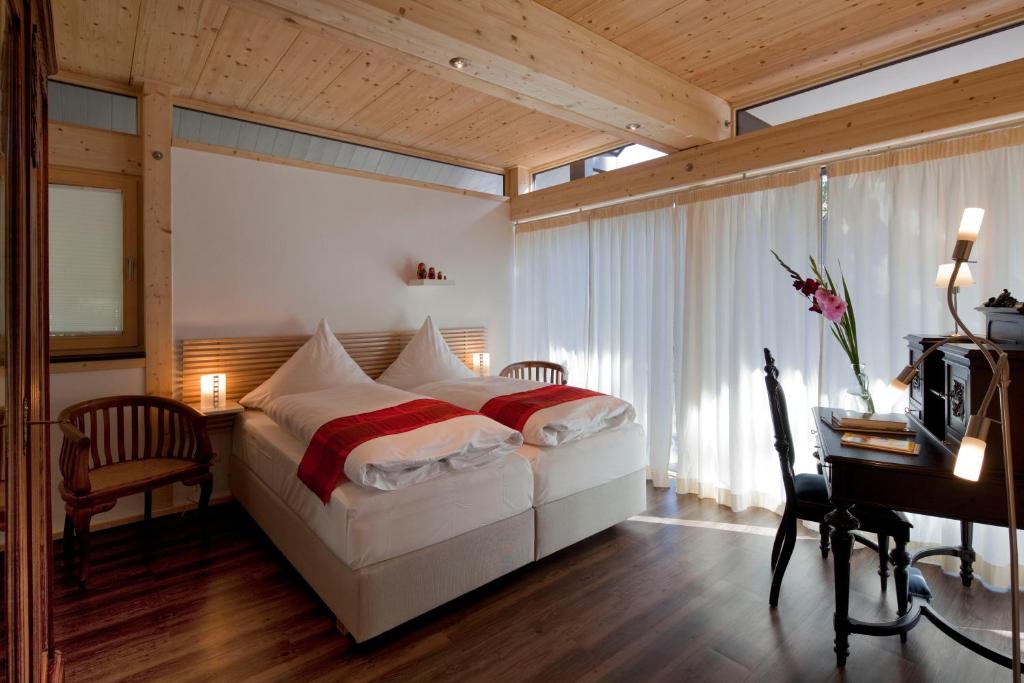 a bedroom with a large bed and a desk and a desk at Vivere Ad Parcum - Bed And Breakfast in Krefeld