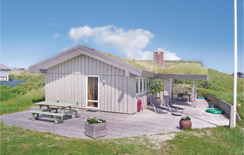 a small white shed with a picnic table and a bench at 3 Bedroom Nice Home In Fan in Fanø