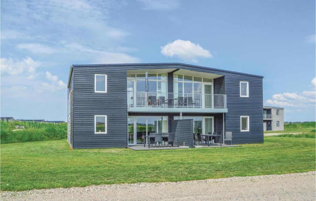 a house on a lawn with a large window at Holiday Home Ringkobing Iii in Søndervig