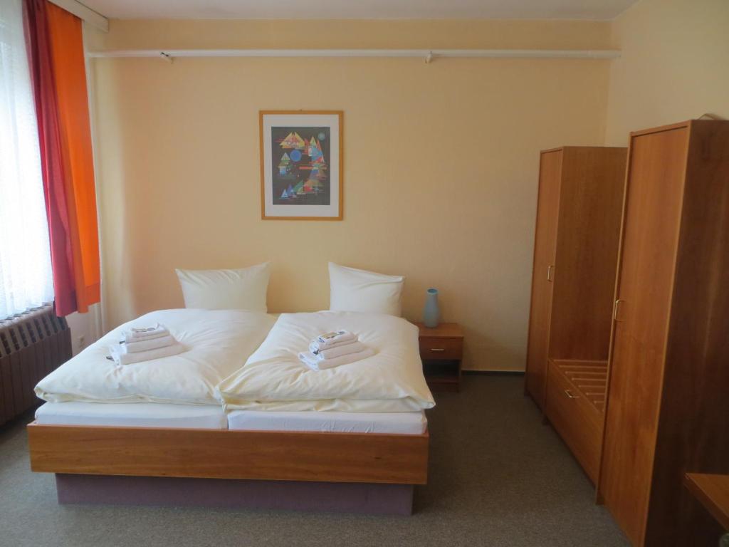 a bedroom with a bed with white sheets at Heidehotel Letzlingen in Letzlingen