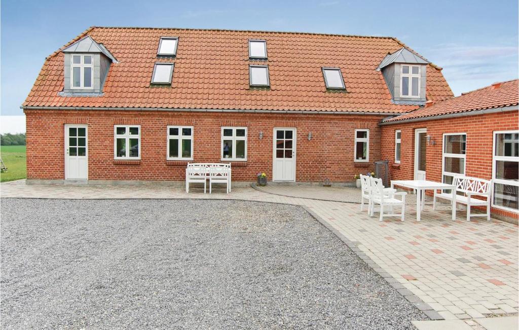 un bâtiment en briques avec une table et des chaises devant lui dans l'établissement Haugstrupgrd, à Filskov