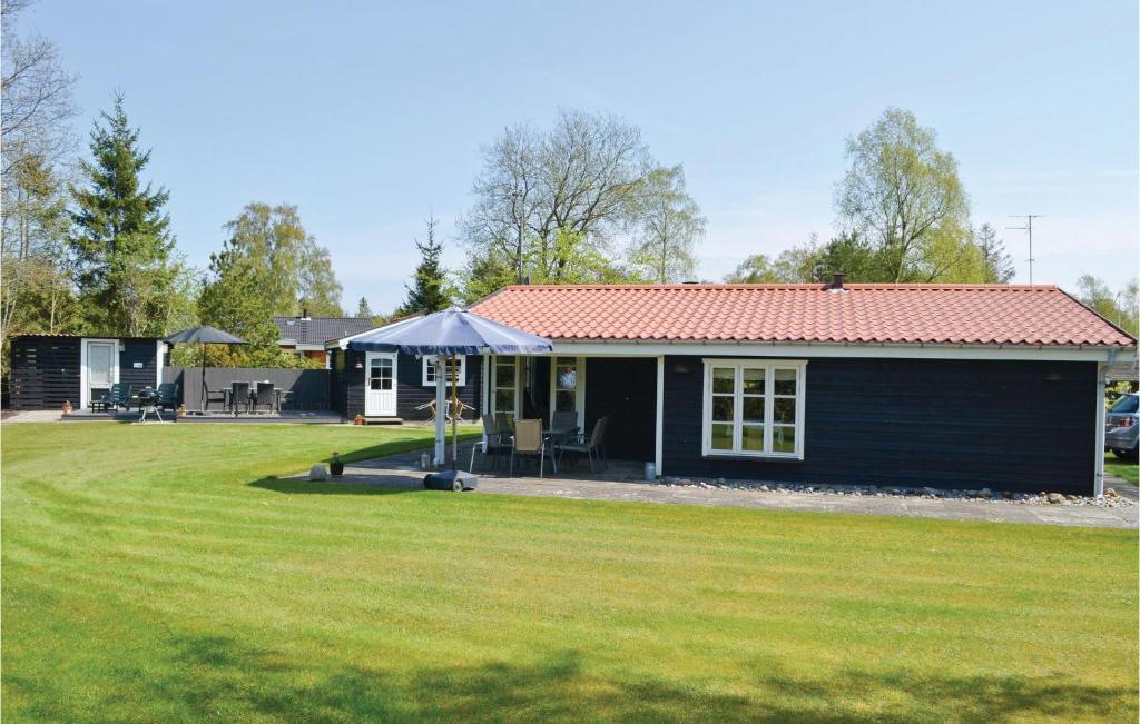 a small black house with a large yard at Holiday Home Bøtø Ringvej in Marielyst