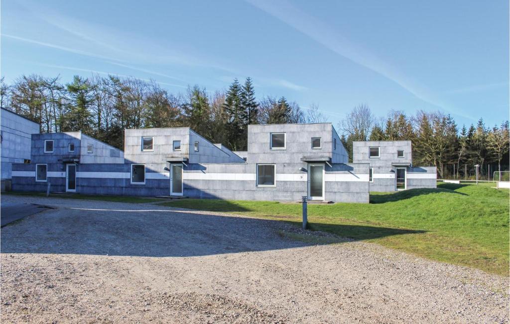 a building that is sitting on top of a field at Amazing Home In Lgumkloster With Wifi And Outdoor Swimming Pool in Løgumkloster