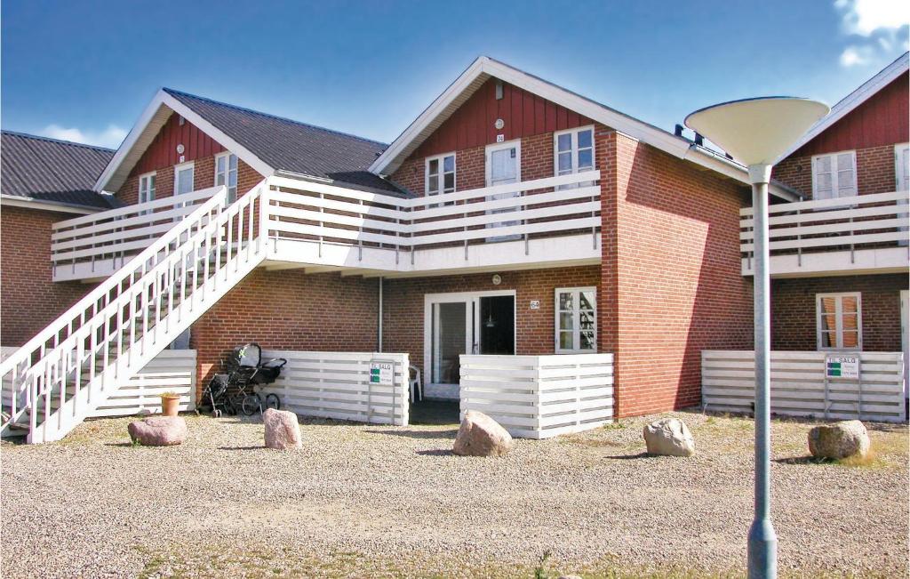 een groot bakstenen huis met een veranda en een trap bij Lejl, 64 in Rømø Kirkeby