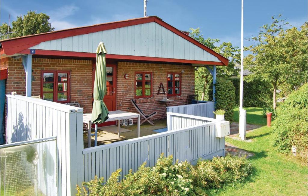 a small house with a white fence in front of it at Nice Home In Broager With Kitchen in Broager