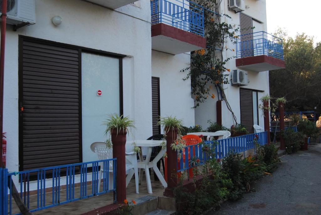 a building with a table and chairs in front of it at Sailors Apartments in Elounda