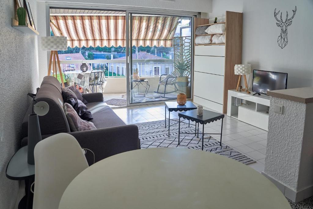 un salon avec un canapé et une table dans l'établissement Studio Ste Sophie, à Cannes