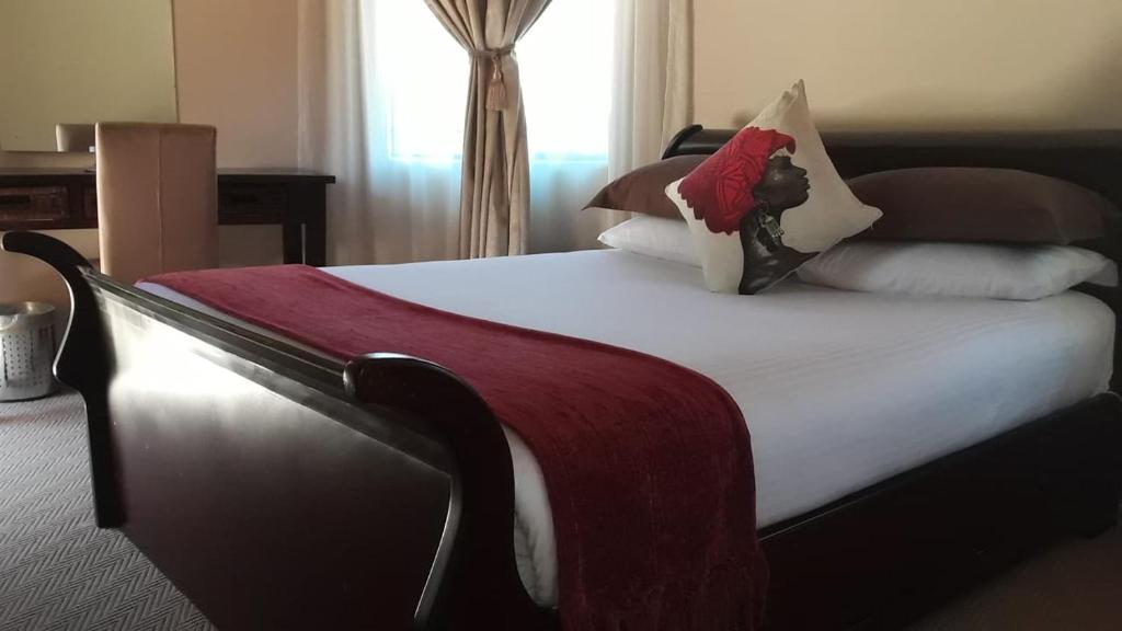 a bedroom with a large bed with pillows at Maluti Stay Lodge in Mphoto