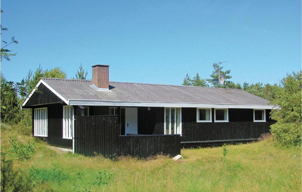 a black house sitting on top of a hill at Holiday Home Uranusvej in Ålbæk