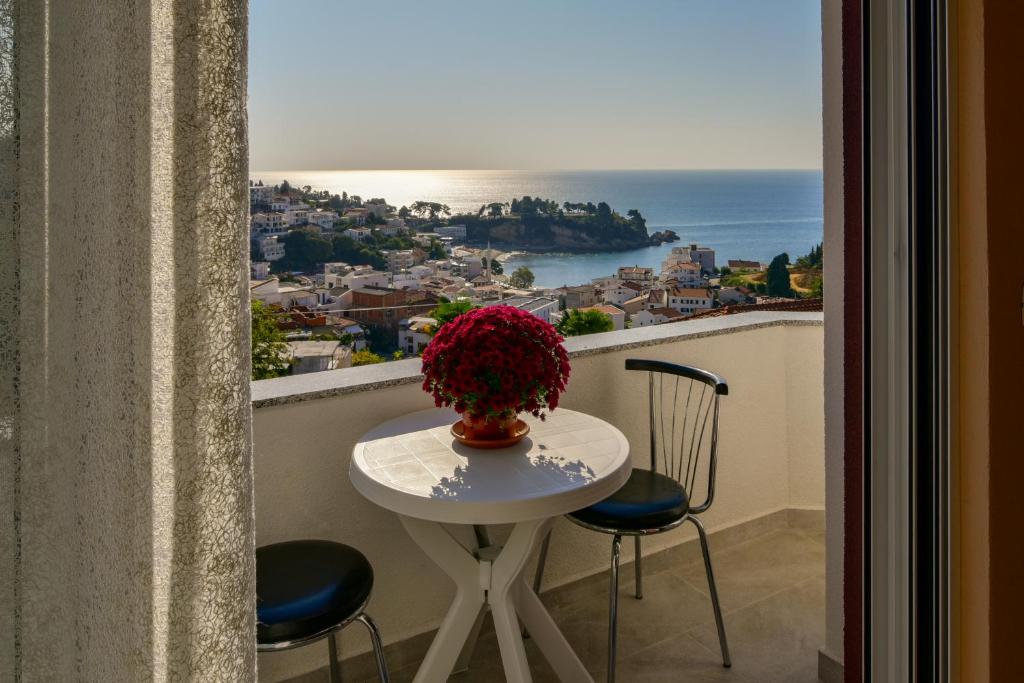a table with a vase of flowers on a balcony at Apartments Hillside in Ulcinj