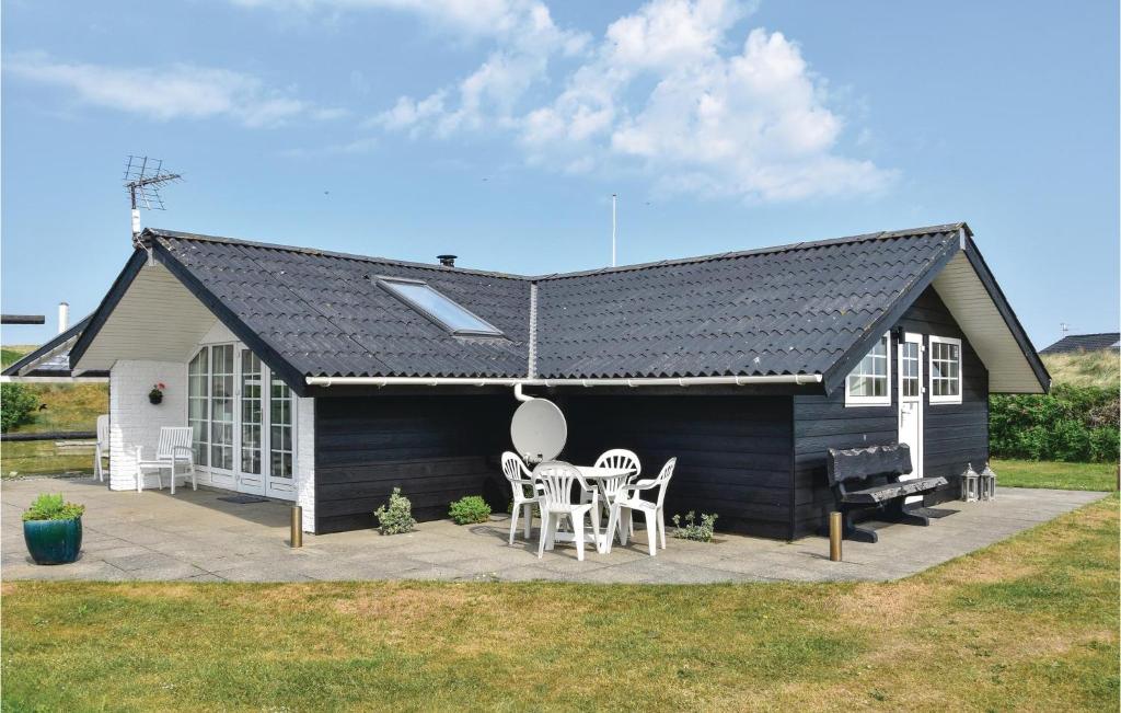 a black and white house with a table and chairs at Stunning Home In Ringkbing With Kitchen in Søndervig
