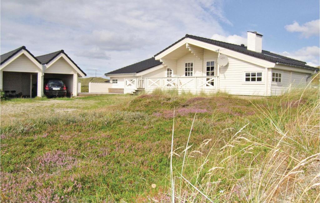 Biały dom na szczycie trawiastego pola w obiekcie Klitten w mieście Havrvig