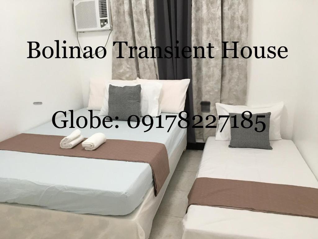two beds in a hotel room with the words balma transient house at Bolinao Transient House B in Balingasay