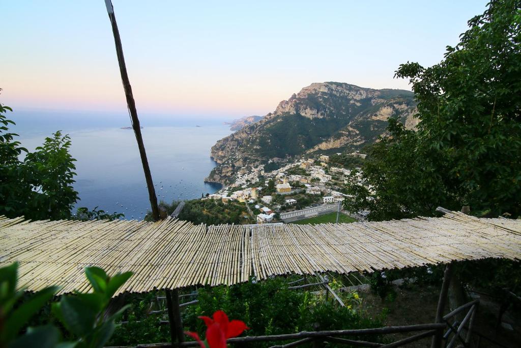einen Blick auf die Amalfiküste von einem Strohschirm in der Unterkunft Colle dell'Ara in Positano