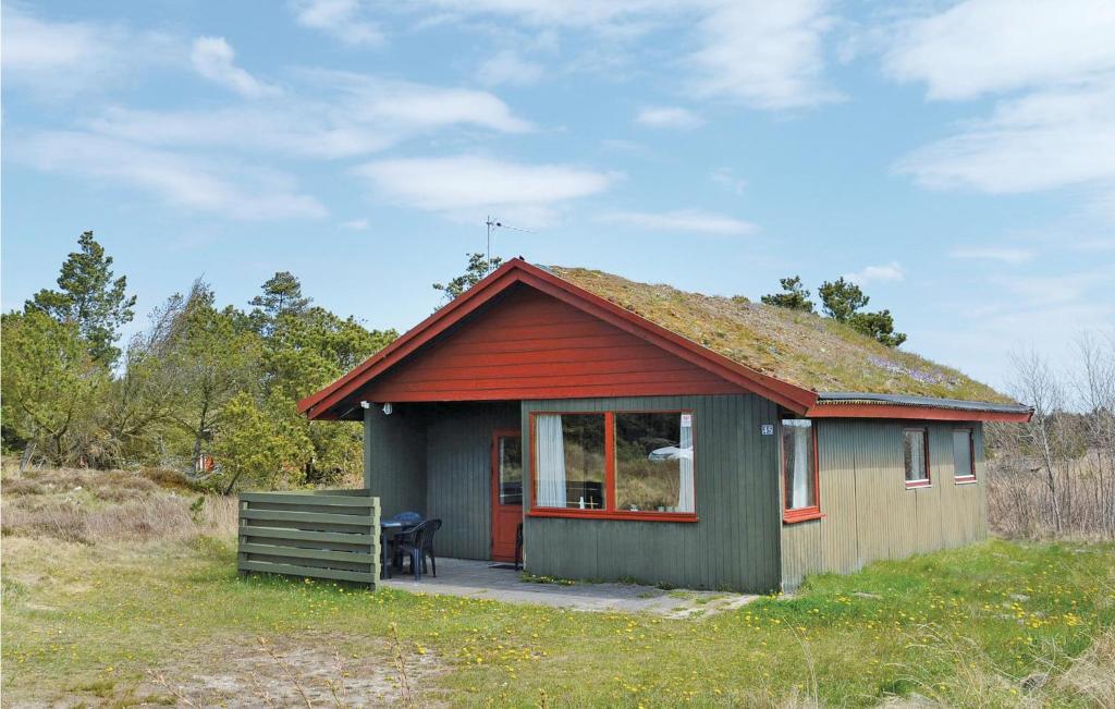 a small house with a grass roof on a field at Cozy Home In Rm With Kitchen in Bolilmark