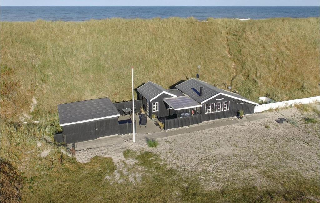 a building on the beach next to the ocean at Three-Bedroom Holiday Home In Ulfborg in Fjand Gårde