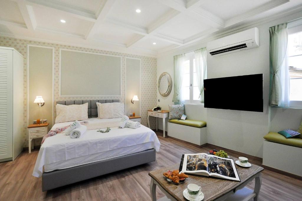 una camera con un grande letto e una TV di CASA VERDE a Città di Corfù