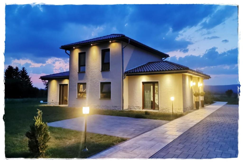 a white house with lights on the driveway at Design Apartment Harz-Relax in Harzgerode