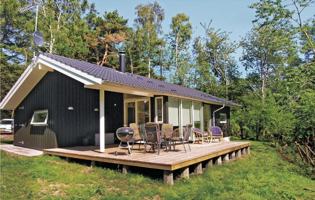 ein schwarzes Haus mit einer Terrasse und Stühlen darauf in der Unterkunft Stunning Home In Rnne With Kitchen in Rønne